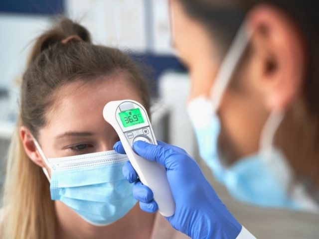 nurse checking a patient's temperature