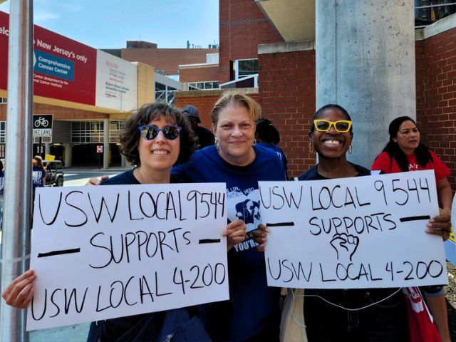 Union President, Judy Danella on the picket line, flanked my rwo nurses holding signs in support of USW Local 4-200.