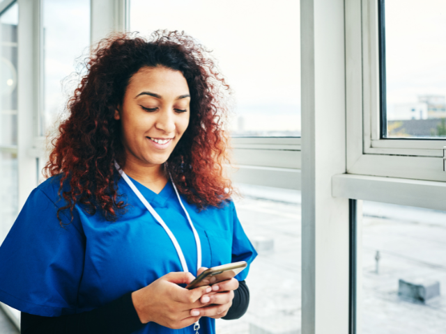 Nurse looking up information to renew LPN license on her cell phone