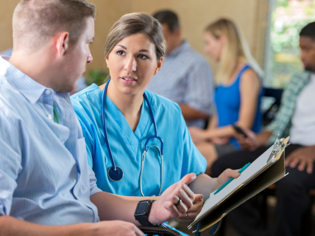 A nurse speaks to a patient, possibly while working under her multi-state practice licensure.