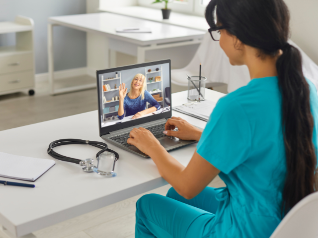 A nurse holds a telehealth appointment, which is one of new nursing models that could improve patient care.